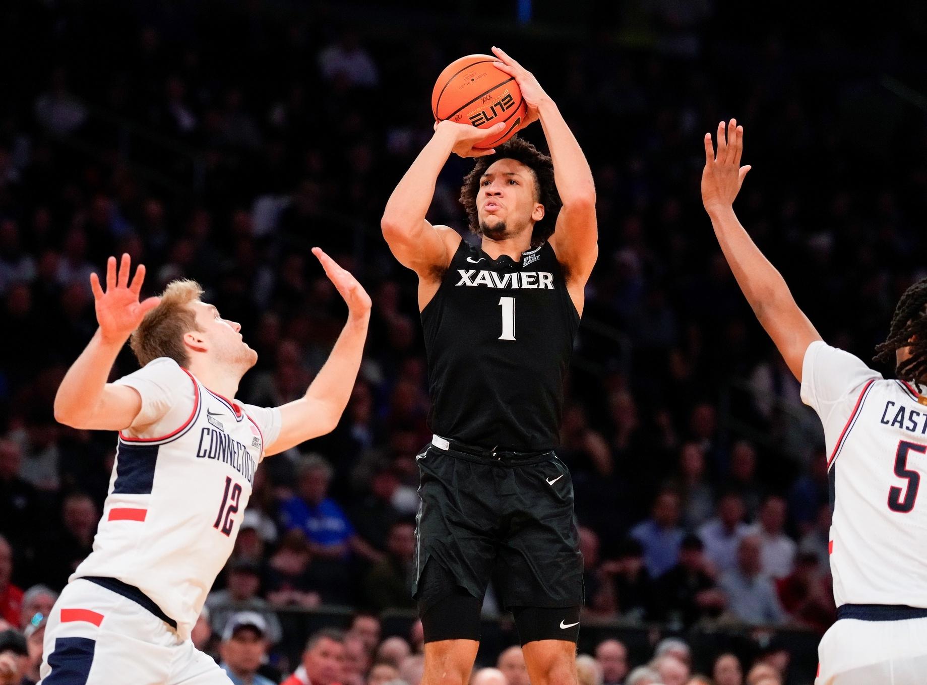 Desmond Claude shoots over multiple UConn defenders